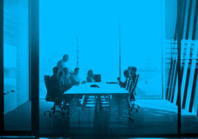 CEO giving peptalk to businesspeople at meeting in big conferenceroom